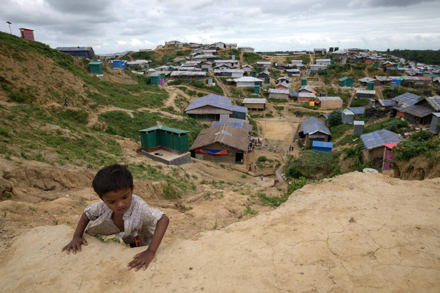 A Rohingya refugee child climbs a slope at the Jamtoli refugee camp near Cox's Bazar on August 12, 2018. / AFP PHOTO / Ed JONES