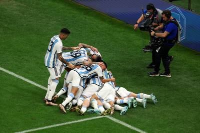 Lionel Messi is mobbed by Argentina teammates after scoring. Getty