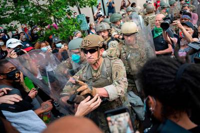TOPSHOT - Protesters scuffle with members of the US Army as they demonstrate the death of George Floyd near the White House on June 3, 2020, in Washington, DC.  Former Minneapolis police officer Derek Chauvin, who kneeled on the neck of George Floyd who later died, will now be charged with second-degree murder, and his three colleagues will face charges of aiding and abetting second-degree murder, court documents revealed on June 3. / AFP / JIM WATSON
