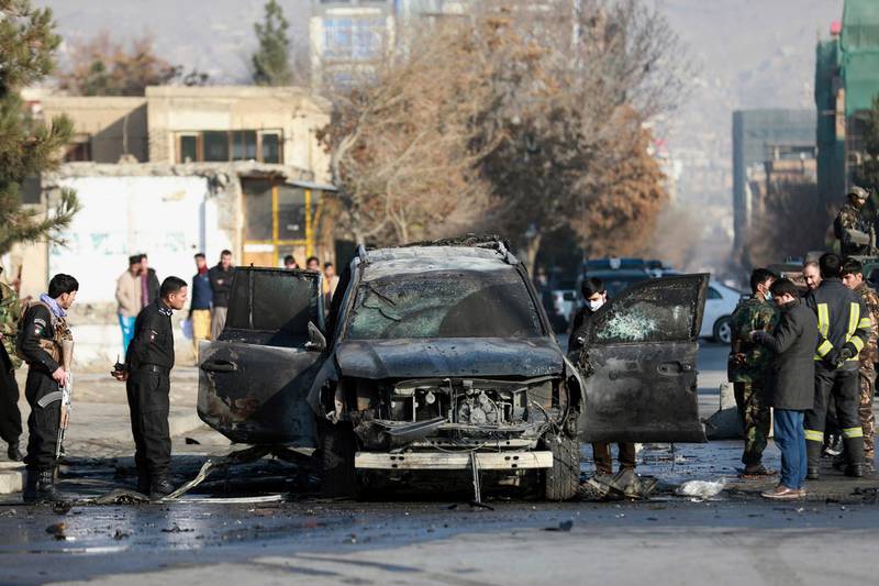 An Afghan security member inspects a damaged vehicle after a bomb blast in Kabul, Afghanistan, Sunday, December 13, 2020. AP