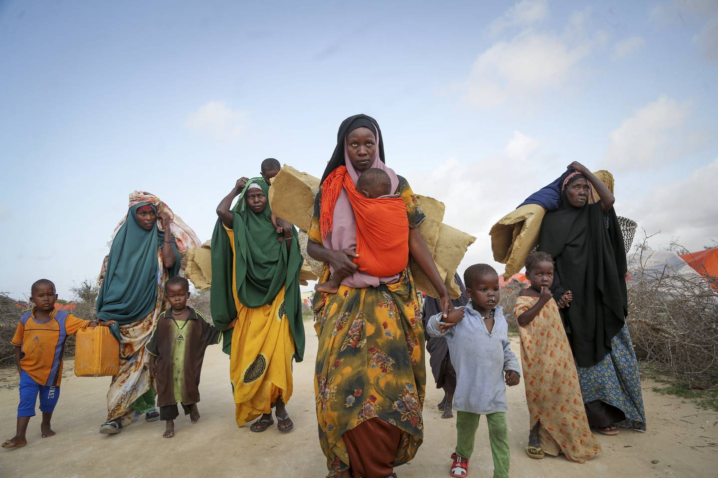 Les Somaliens qui ont fui les zones touchées par la sécheresse transportent leurs affaires dans un camp pour personnes déplacées, près de Mogadiscio, le 30 juin. AP