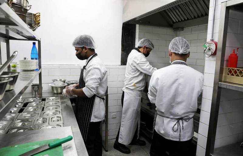 DUBAI , UNITED ARAB EMIRATES , November 25 – Staff  members of the Vasai Local restaurant preparing food in the restaurant kitchen in Al Karama area in Dubai. Vasai Local Restaurant is providing food for the campaign run by St Mary Church which are giving meals to the poor or those who lost their jobs. ( Pawan Singh / The National ) For News/Online. Story by Patrick