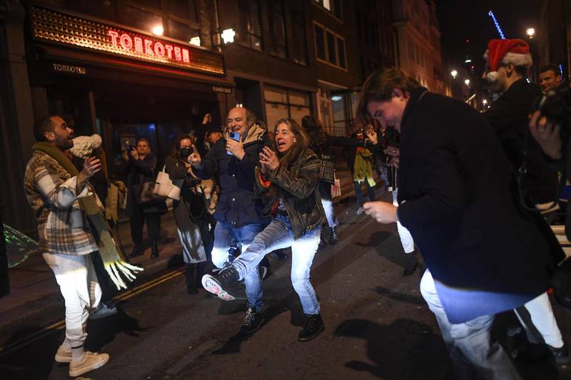 People are seen dancing in the street in Soho, ahead of London being moved into Tier 3. Getty Images