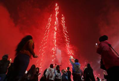 People watch as Dubai celebrates the new year with a light and sound extravaganza at midnight at Burj Khalifa on January 1, 2015. Karim Sahib / AFP Photo