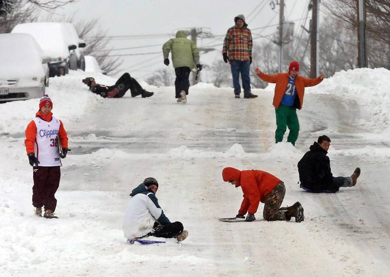 A group of friends from Blacksburg’s Young Life chapter took to the streets to tryout sliding on lunch trays, sleds and their shoes during a winter storm, in Blacksburg, Virginia. Matt Gentry / The Roanoke Times via AP