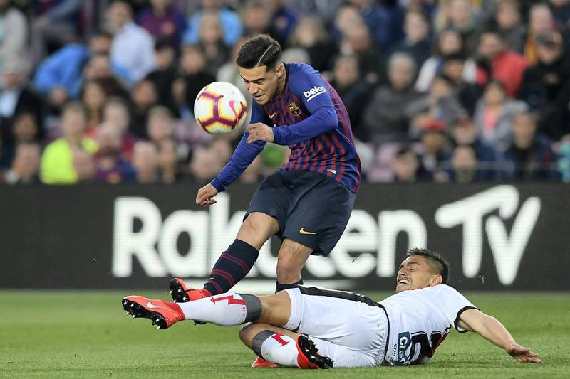 Barcelona's Brazilian midfielder Philippe Coutinho (up) vies for the ball with Rayo Vallecano's Uruguayan defender Emiliano Velazquez during the Spanish league football match between FC Barcelona and Rayo Vallecano de Madrid at the Camp Nou stadium in Barcelona on March 9, 2019. (Photo by LLUIS GENE / AFP)