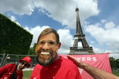 A Liverpool fan wears a Jurgen Klopp mask in Paris. Reuters