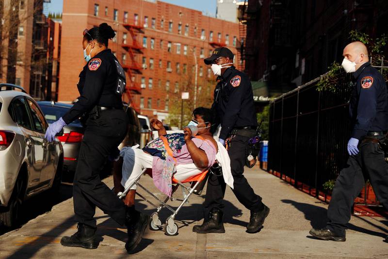 A New York City Fire Department (FDNY) Emergency Medical Technician (EMT) wearing personal protective equipment assist a woman who was having difficulty breathing during ongoing outbreak of the coronavirus disease (COVID19) in New York, U.S. REUTERS