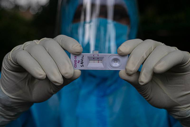 A health worker shows a sample kit of a Covid-19 positive test during a door-to-door test drive in Gauhati, India. AP Photo