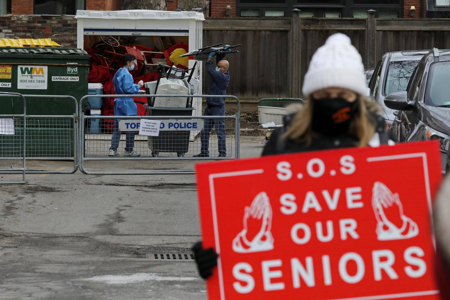 FILE PHOTO: Health workers dispose of furniture outside the Sienna St. George long term care home, as protesters hold a rally to demand that Sienna Senior Living invest more on resident care and staff safety amid the coronavirus disease (COVID-19) outbreak, in Toronto, Ontario, Canada January 10, 2021.  REUTERS/Chris Helgren/File Photo