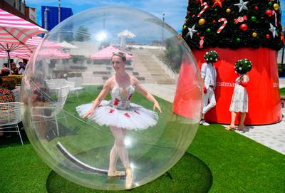 A ballet dancer poses in a giant plastic bubble as she entertains Christmas shoppers in Melbourne, Australia on December 13. AFP