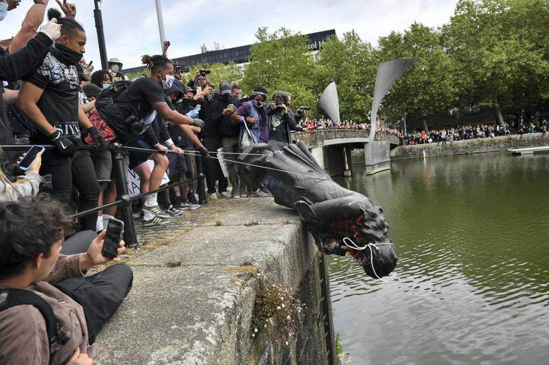 Protesters throw statue of Edward Colston into Bristol harbour during a Black Lives Matter protest rally, in memory of George Floyd who was killed on May 25 while in police custody in the US city of Minneapolis. (Photo by Ben Birchall/PA Images via Getty Images)
