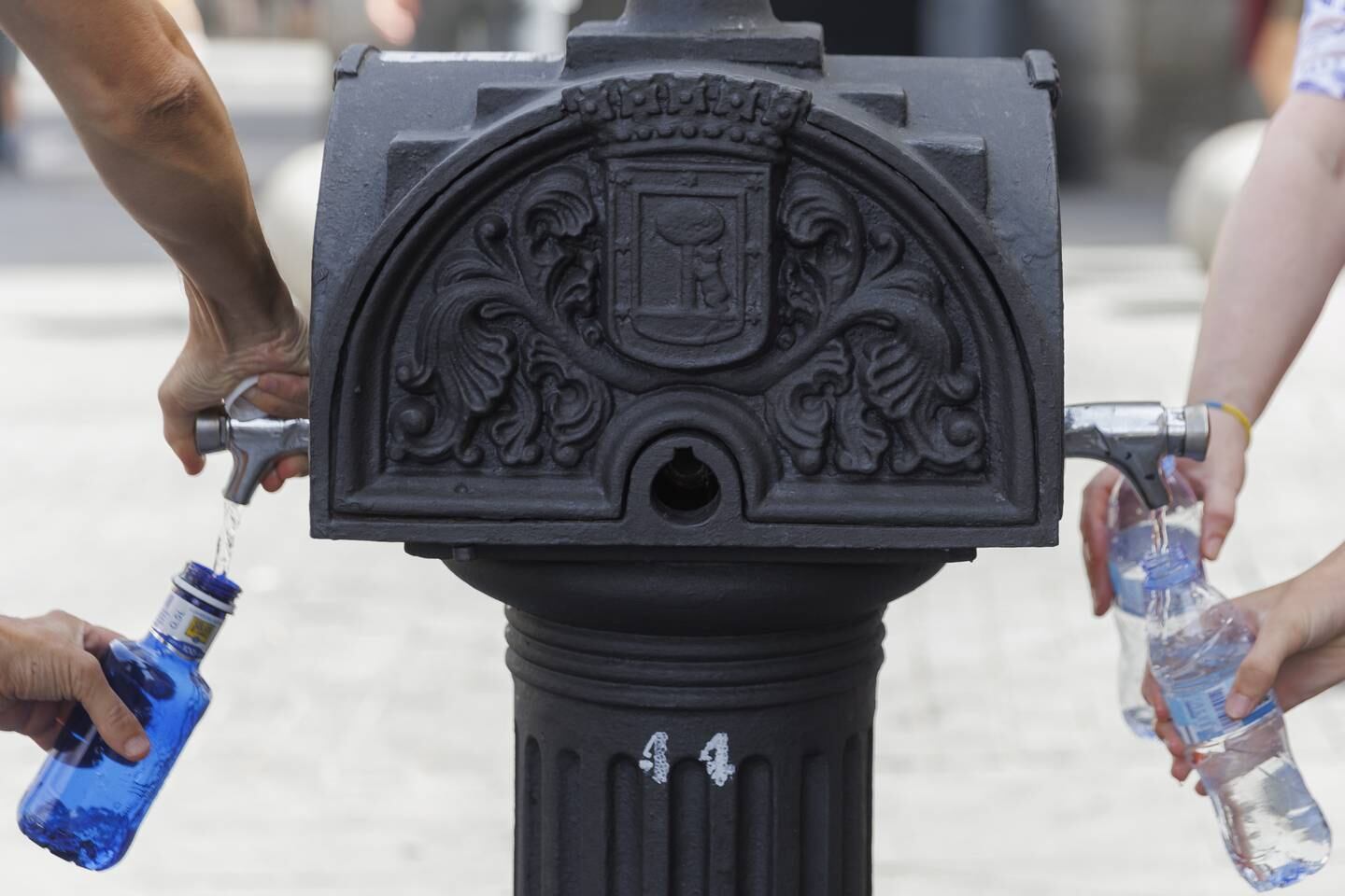 People refilling water bottles at a fountain in downtown Madrid. EPA 