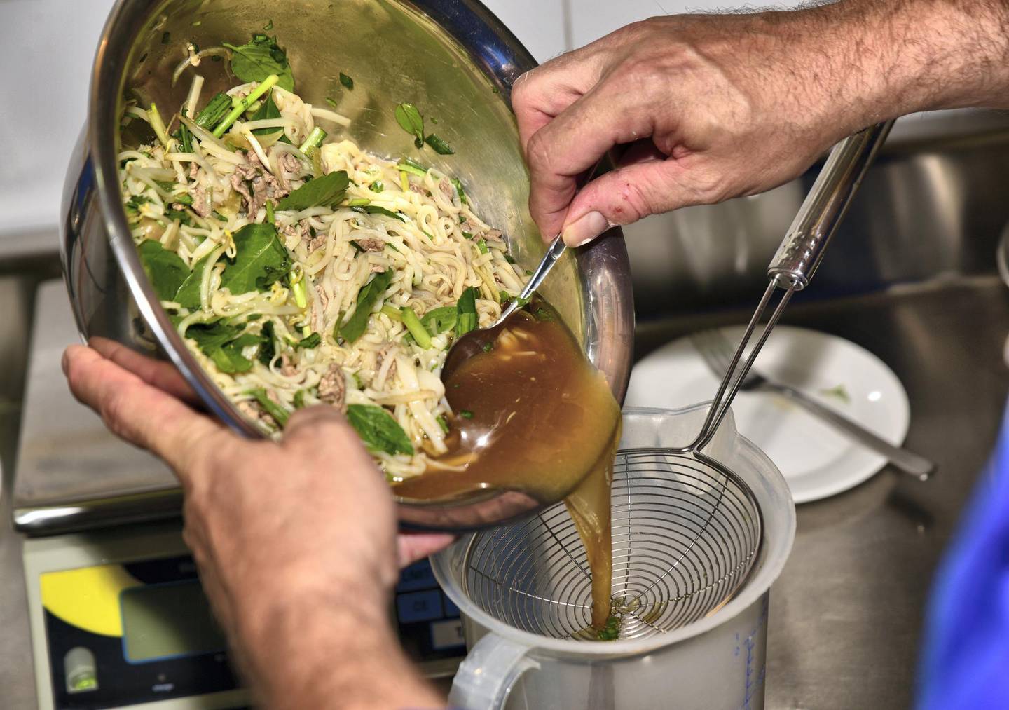 Gelato-maker Ralf Ehresmann passes pho soup through a sieve before turning it into gelato. Photo: Ronan O’Connell