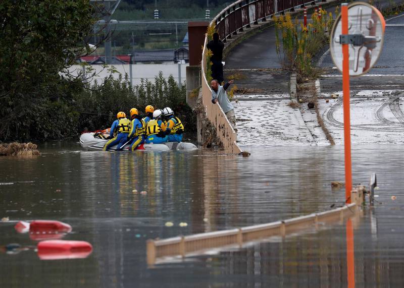 A man talks with rescue workers searching a flooded area. Reuters