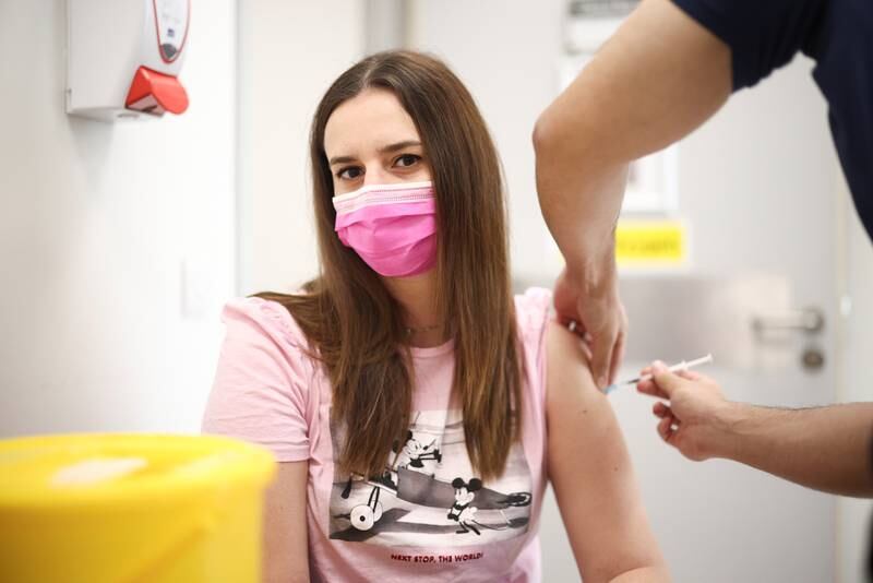 A person receives a dose of the Pfizer/BioNTech vaccine at the Central Middlesex Hospital in London.