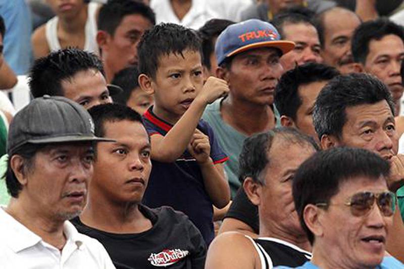 A young Filipino fan of Manny Pacquiao gestures while watching a free live broadcast of his match. Romeo Ranoco / Reuters