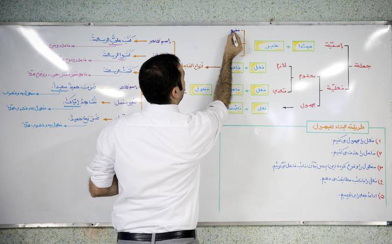 Should university courses be taught in Arabic, as teacher Ammar Tajbakhsh shows here, or in English, which would ensure graduates have wider opportunities? Photo by Maryam Rahmanian