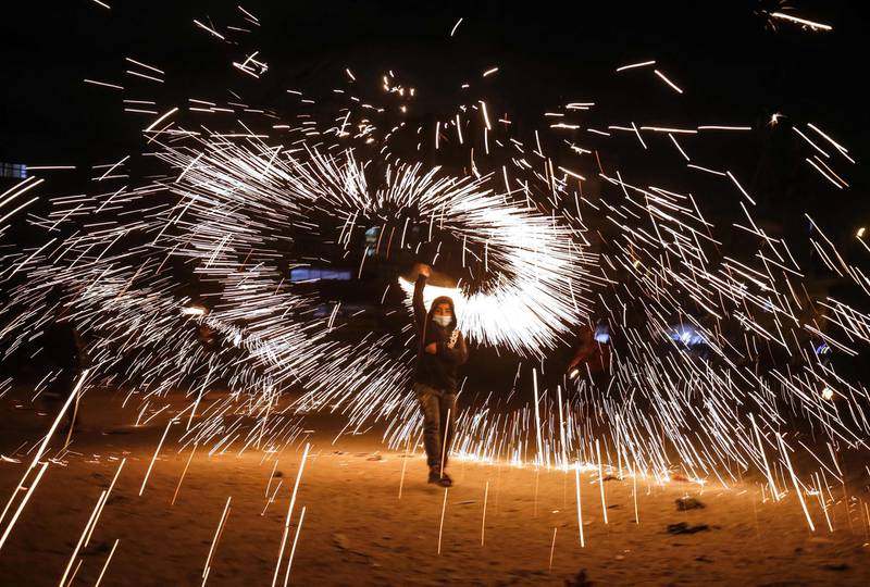A Palestinian boy waves fireworks as people celebrate the start of the Muslim holy fasting month of Ramadan in the southern Gaza Strip town of Rafah. AFP