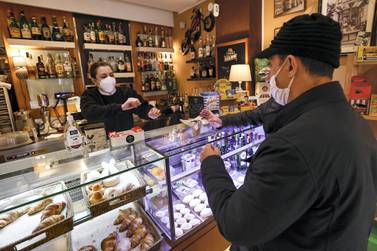 A worker serves a customer at a coffee shop as the town is downgraded from a red to an orange zone, after weeks of tight restrictions to fight the coronavirus disease (COVID-19) outbreak, in Naples, Italy, April 19, 2021. REUTERS/Ciro de Luca