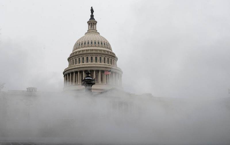 (FILES) In this file photo taken on December 16, 2020 mist from a steam pipe is seen coming from a grate near the US Capitol as a snow storm develops in Washington, DC. US lawmakers on December 21 took the first step toward approving a $900 billion relief package for Americans hard hit by the pandemic, as Congress raced to finalize the massive legislation ahead of a midnight deadline. / AFP / ANDREW CABALLERO-REYNOLDS
