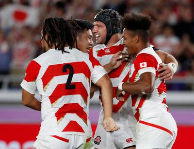Japan players celebrate with Kotaro Matsushima after scoring their first try. Reuters