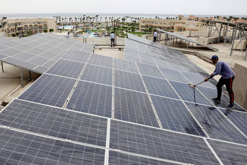 A worker cleans solar cells on the rooftop of a hotel in Sharm El Sheikh. Reuters