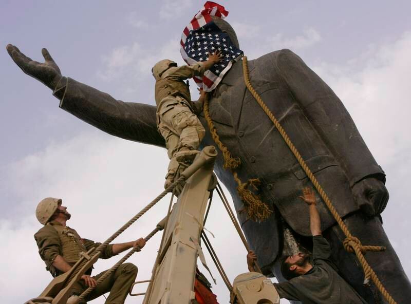 American soldiers cover the face of a statue of Saddam Hussein with a US flag in Baghdad in April 2003. AP