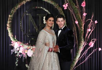 epa07208512 Newlyweds, Bollywood actress Priyanka Chopra (L) and US musician Nick Jonas (R) pose for photographs during a reception in New Delhi, India, 04 December 2018. According to media reports, the couple hosted wedding celebrations in Jodphur on 01 and 02 December.  EPA/RAJAT GUPTA