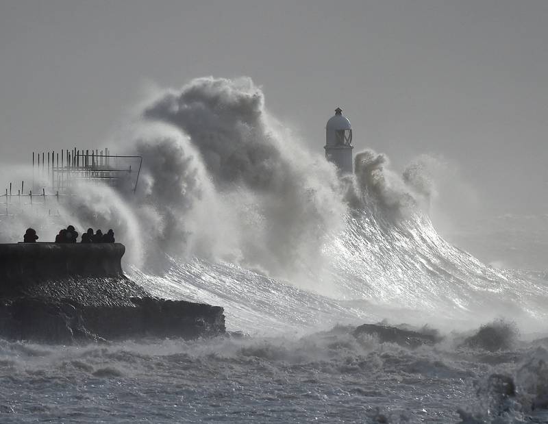 Waves crash against a lighthouse during Storm Franklin in Porthcawl, Wales. Reuters