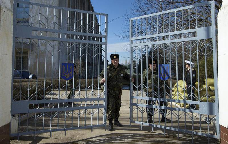 A Ukrainian soldier closes the naval base headquarter gate in the town of Novo-Ozerne, Ukraine, on Monday March 3, 2014. Ivan Sekretarev / AP photo