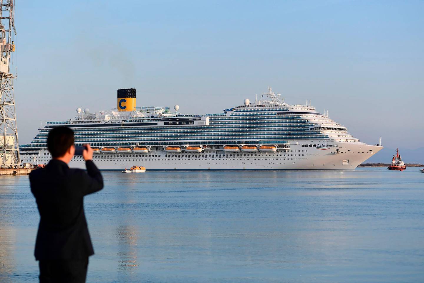 A Chinese observer takes a picture of the Costa Venezia cruise (Costa group), a ship specially designed for Chinese tourists on the theme of Venice, leaving the port of the Italian company Fincantieri shipyard in Monfalcone on February 28, 2019.
 The Costa Cruises' Costa Venezia will be able to accommodate 5,260 Chinese tourists, who will travel between Shanghai and Japan. / AFP / Miguel MEDINA
