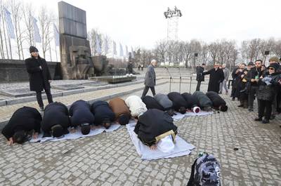 A delegation of Muslim religious leaders perform prayers during a visit to the former Nazi death camp of Auschwitz. American Jewish Committee via AP