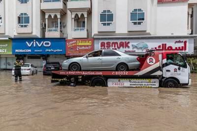 Civil defence workers help to recover cars in water-logged Fujairah city. Antonie Robertson / The National
