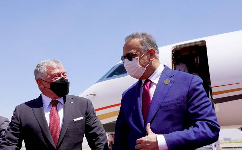 Iraqi Prime Minister Mustafa Al Kadhimi receives Jordan's King Abdullah II upon his arrival at the airport in the capital Baghdad to attend a regional summit. AFP