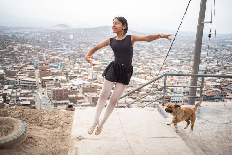 The city sprawls out in the background as a young ballerina dances 