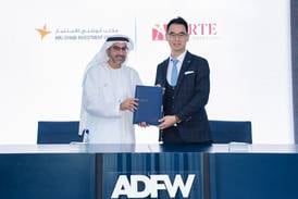 Badr Al Olama, director general of the Abu Dhabi Investment Office, and Ethan Chan, chairman of Arte Capital Group, welcome a preliminary agreement at Abu Dhabi Finance Week. Photo: Adio