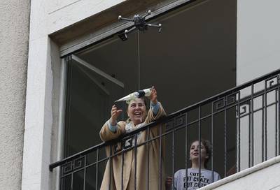 A woman standing on her balcony, reaches out to catch a rose delivered to her via a drone on Mother's day, in the Lebanese coastal city of Jounieh, north of the capital Beirut, as people remain indoors in an effort to limit the spread of the novel coronavirus.  In a quiet Lebanese town under lockdown over the novel coronavirus, a drone buzzed towards a balcony on Saturday to deliver a red rose to a mother grinning in surprise. The COVID-19 pandemic may have put a damper on Mother's Day this year, but three students have come up with a novel service to celebrate the occasion without flouting social distancing restrictions. AFP