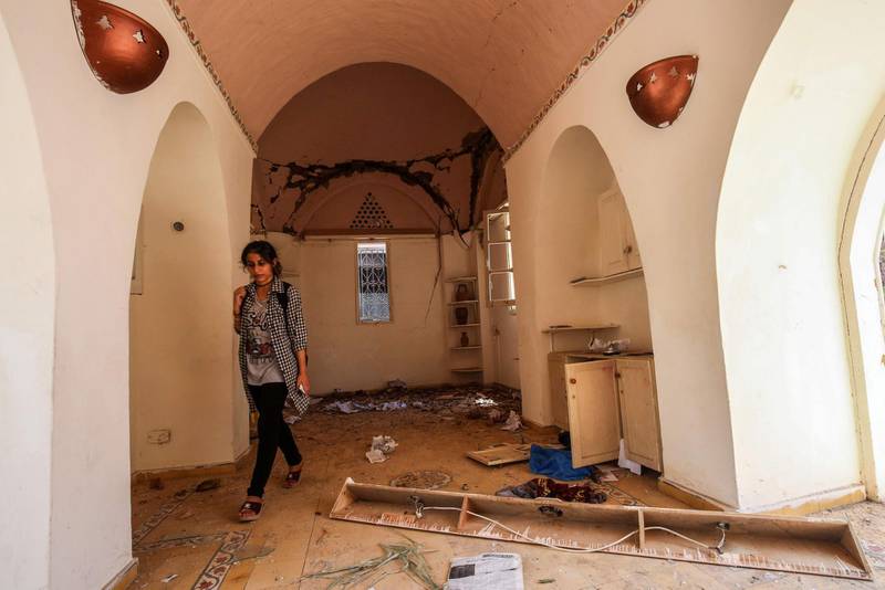 A Palestinian woman inspects damages in the showroom of Gaza the Arts and Crafts Village, adjacent to a building that was hit by Israeli air strikes two days earlier in Gaza City, on July 16, 2018. / AFP / SAID KHATIB
