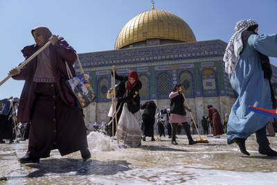 Palestinian volunteers clean the Al-Aqsa compound, in front of the Dome of Rock Mosque in Jerusalem's Old City. AP