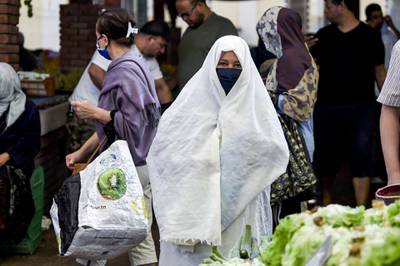 A woman clad in veil and face mask due to the COVID-19 coronavirus pandemic walks at the central market in Tunisia's capital Tunis on October 4, 2020. Tunisia's Prime Minister Hichem Mechichi announced late on October 3 a set of new measures aimed at curbing the spread of the novel coronavirus in the North African country, including a ban on all gatherings and stressing the importance of wearing face masks to limit the spike in new cases. / AFP / FETHI BELAID
