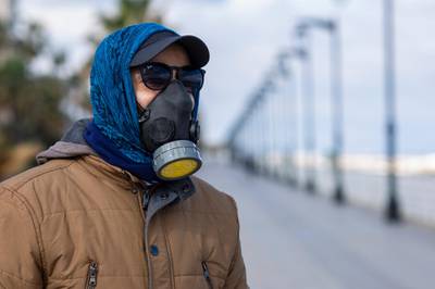 A man wears a tear gas mask to help protect himself from the new coronavirus as he walks at Beirut's seaside corniche, or waterfront promenade, along the Mediterranean Sea, which is almost empty of residents and tourists in Beirut, Lebanon. For most people, the new coronavirus causes only mild or moderate symptoms, such as fever and cough. For some, especially older adults and people with existing health problems, it can cause more severe illness, including pneumonia. AP Photo