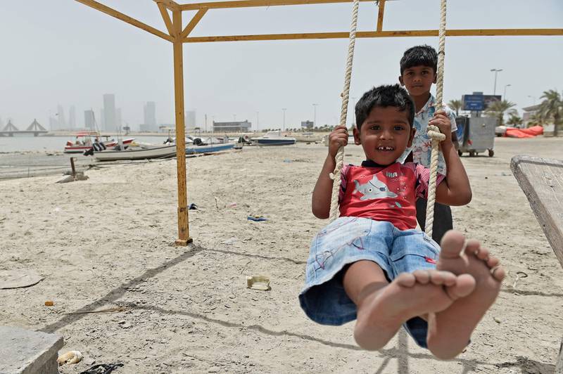 Children play outside during a sandstorm on Muharraq Island, north of the Bahraini capital Manama. People in the Mena region are being advised to stay indoors, especially babies and at-risk groups, and to avoid physical exercise.  AFP