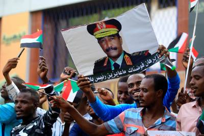 Sudanese supporters of the ruling Transitional Military Council (TMC) hold up a sign showing a portrait of its head General Abdel Fattah al-Burhan with a caption below reading in Arabic "we have delegated you Burhan, we want no president but you", during a rally in the centre of the capital Khartoum on May 31, 2019. (Photo by ASHRAF SHAZLY / AFP)