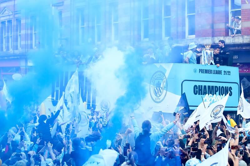Fans celebrate as the Manchester City team go past on the bus. Getty