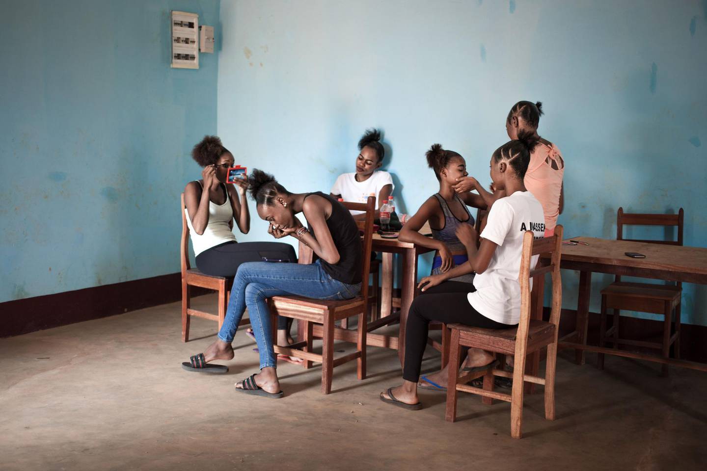 A Miss Central African Republic 2018 contestants puts on make-up at the boarding school where the contestants reside before the contest, in Bimbo, on December 9, 2018. The Miss Central African Republic beauty pageant has disappeared from the country since 2015, and resurrected thanks to Russia, already present through military donations. / AFP / FLORENT VERGNES
