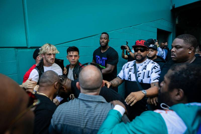 Logan Paul is restrained by security while people clash during a press conference at Hard Rock Stadium, in Miami Gardens, Florida. AFP
