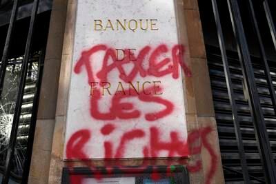 Graffiti on the facade of the Bank of France in Paris reads: 'Tax the rich.' AP