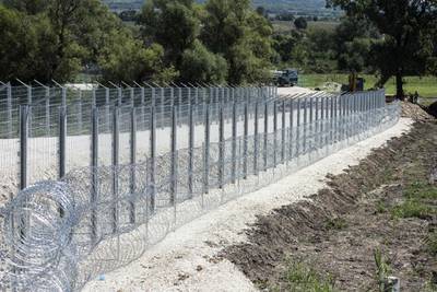 Construction workers work on a fence on the Serbian side at the border with North Macedonia near the northern village of Tabanovce, on August 22, 2020.
 Serbia's government has refused to comment on the construction of a fence near its border with North Macedonia, a common crossing point for migrants traversing the Balkan region. The barrier is being erected on Serbia's southern frontier, close to an official border crossing and a migrant camp on North Macedonia's side, according to an AFP photographer. 
 / AFP / Robert ATANASOVSKI
