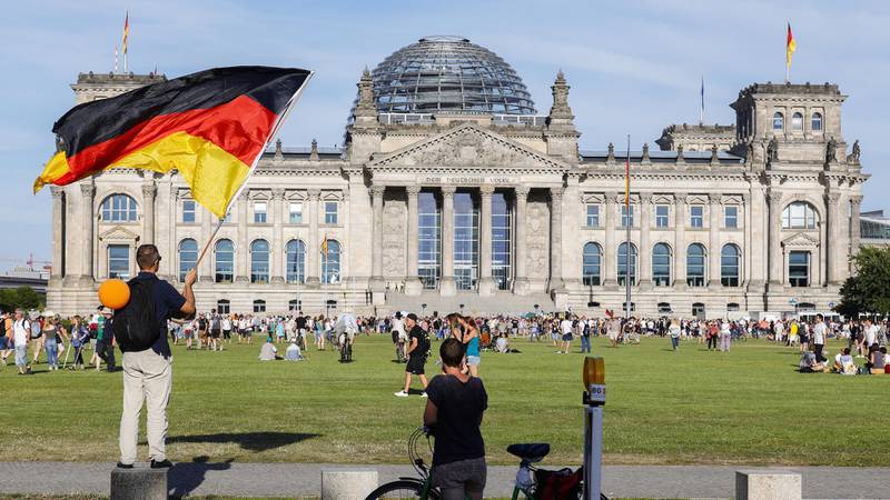 A demonstrator waves a flag in front of the Reichstag building, the seat of the German parliament, following a protest against coronavirus pandemic regulations in Berlin, Germany.  EPA